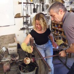 A Glassmaker Helping a Visitor